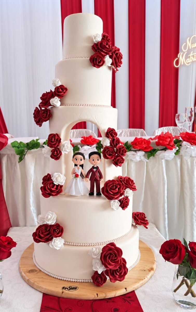Torta monumental de boda con arco floral y novios elaborada en Santo Tomás por Pastelería Shamy